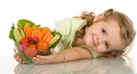 Little girl leaning on the table with a bowl of vegetables - nutrition